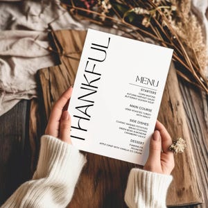 May include: A Thanksgiving menu with the word "THANKFUL" in large black letters at the top. The menu lists starters, main course, side dishes, and dessert. The menu includes items like corn muffins, butternut squash soup, herb-roasted turkey, mashed potatoes, bread stuffing, cranberry sauce, pumpkin pie, and pecan pie.