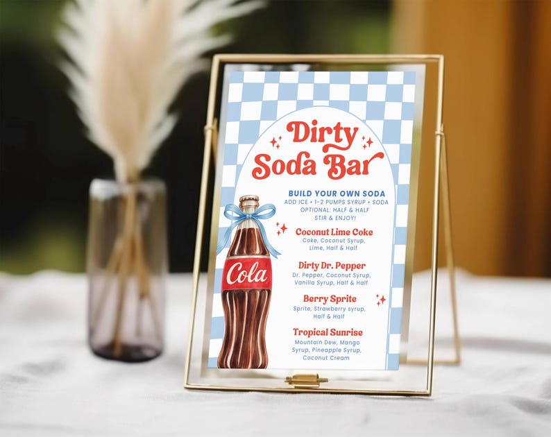 May include: A gold-framed sign for a "Dirty Soda Bar" with a blue and white checkered background. The sign features a cola bottle illustration and a menu with soda recipes like Coconut Lime Coke and Berry Sprite.