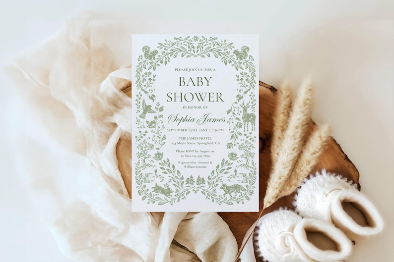 May include: A baby shower invitation with a green floral wreath design, featuring woodland creatures. The invitation includes the text "Baby Shower" and the name "Sophia James". The invitation is accompanied by white baby booties.