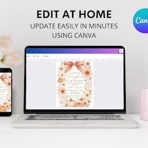 May include: A laptop, smartphone, and a pink mug are on a white surface. The laptop and smartphone display a baby shower invitation with a pumpkin theme. The invitation has text that reads "A Little Pumpkin is on the Way!" and "Edit at Home Using Canva."