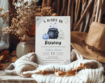 Könnte beinhalten: Eine rechteckige Einladungskarte für eine Babyparty mit dem Text A BABY IS BREWING, einem schwarzen Kessel, einem hellblauen Kürbis und einem kleinen Geist. Das Design enthält Spinnennetze, einen Halbmond und die Veranstaltungsdetails.