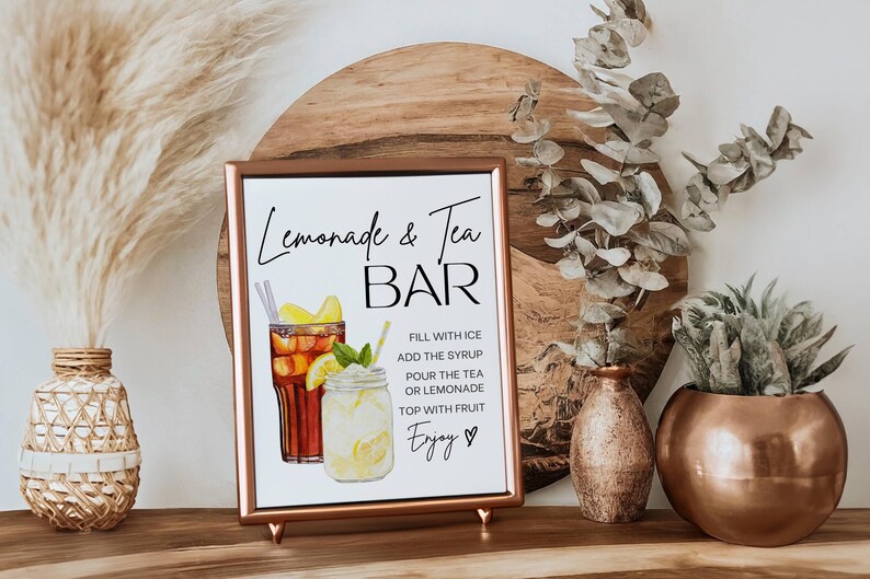 May include: A framed sign with the text "Lemonade & Tea BAR" and instructions for making the drinks. The sign features watercolor illustrations of iced tea and lemonade. Decorative vases and plants are in the background.