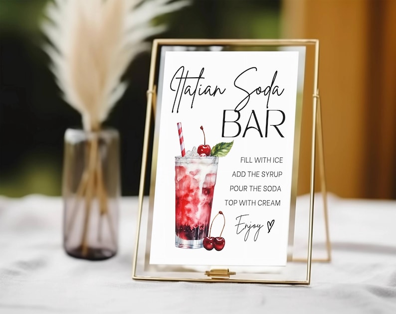 Op de afbeelding: Een printbaar bord voor een "Hatian Soda Bar" met een aquarel-illustratie van een glas soda met een kers en een rietje. Het bord bevat instructies voor het maken van de soda: "Vul met ijs, voeg de siroop toe, giet de soda, top met slagroom, geniet."
