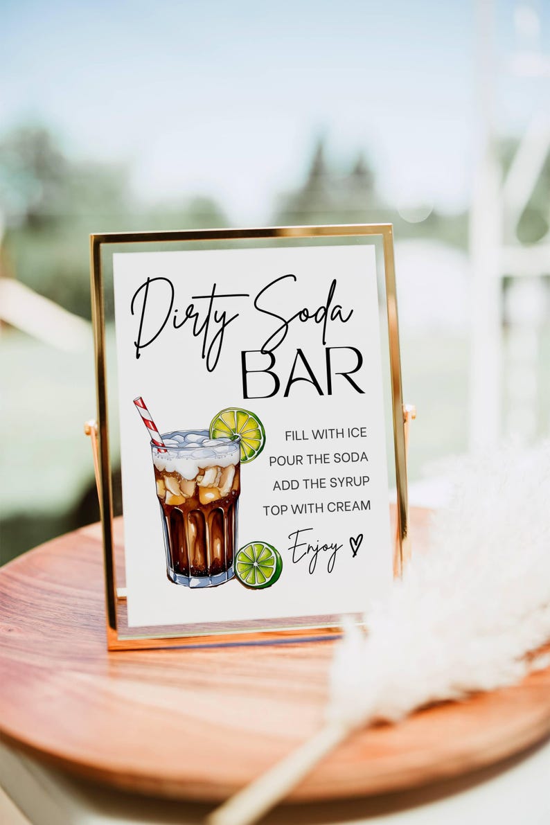 May include: A white sign with black text and a drawing of a dirty soda drink. The sign reads "Dirty Soda Bar" and includes instructions for making the drink: "Fill with ice, pour the soda, add the syrup, top with cream. Enjoy!"