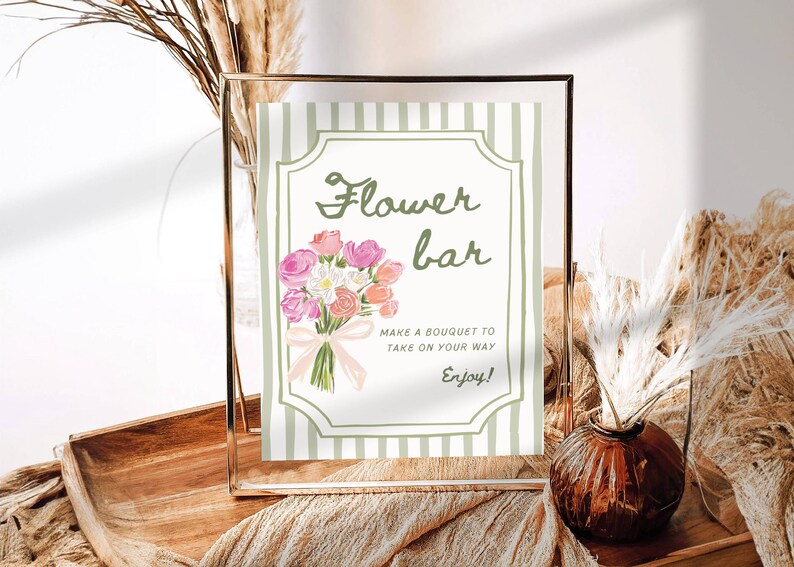 May include: A framed sign with the words "Flower bar" and a watercolor bouquet illustration. The sign has a green and white striped background and includes the text "Make a bouquet to take on your way. Enjoy!"