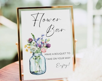 Può includere: Un cartello rettangolare in una sottile cornice dorata con il testo Flower Bar, Make a bouquet to take on your way e Enjoy! Il cartello presenta un'illustrazione ad acquerello di un barattolo di vetro riempito con fiori viola, gialli e rosa.