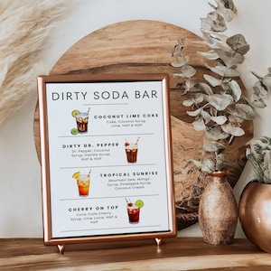 May include: A framed sign with a copper-colored frame displays a "DIRTY SODA BAR" menu. The menu features illustrations and descriptions of four soda concoctions: Coconut Lime Coke, Dirty Dr. Pepper, Tropical Sunrise, and Cherry on Top.