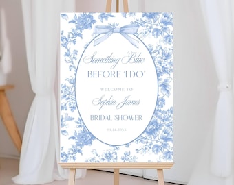 May include: A rectangular bridal shower sign featuring a blue and white floral toile pattern. The center oval frame contains a light blue bow and the text: Something Blue BEFORE I DO, WELCOME TO Sophia James BRIDAL SHOWER, 05.14.20XX.