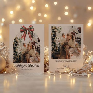 May include: Two Christmas cards with a festive red and green bow on the top. The card on the left has a photo of a family in front of a Christmas tree. The card on the right has a photo of a family in front of a Christmas tree and the text "Wishing you a Merry Holiday Season filled with joy, love and laughter".