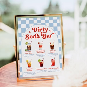 May include: A framed sign with a gold border displays a "Dirty Soda Bar" menu. The sign features a blue and white checkered background and six colorful soda drink illustrations with their ingredients listed below.