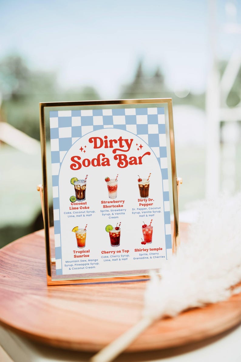 May include: A framed sign with a gold border displays a "Dirty Soda Bar" menu. The sign features a blue and white checkered background and six colorful soda drink illustrations with their ingredients listed below.