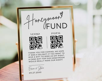 May include: A rectangular gold-toned metal frame holding a white sign that reads Honeymoon Fund with Venmo and Paypal QR codes, a thank you message, and the names Erica & Steve with the date 09.27.20XX printed in black ink.