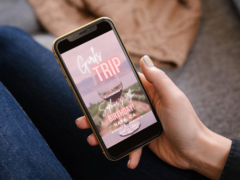 Pode incluir: A tela de um smartphone rosa e branco exibindo um convite digital para uma viagem de meninas para Napa, Calif&oacute;rnia. O convite apresenta uma ta&ccedil;a de vinho e o texto "Girls Trip", "Honoring Sophia's 30th Birthday!" e "August 8-August 9".