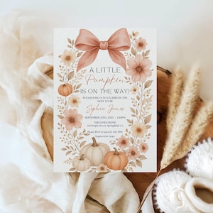 May include: A baby shower invitation with a watercolor design. The invitation features a bow, pumpkins, and floral elements in shades of peach and cream. Text reads "A Little Pumpkin is on the Way!" and includes event details.