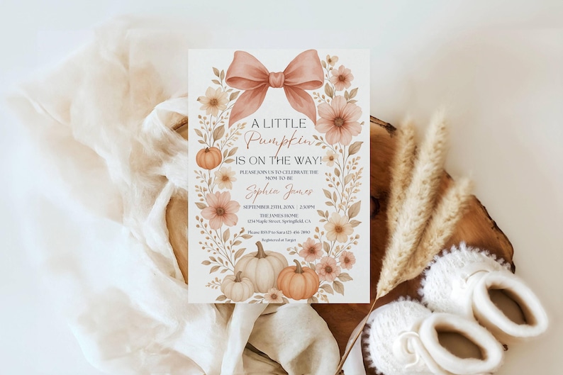 May include: A baby shower invitation with a watercolor design. The invitation features a bow, pumpkins, and floral elements in shades of peach and cream. Text reads "A Little Pumpkin is on the Way!" and includes event details.