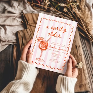 May include: A pink and white striped invitation with the text "a spritz older" and a cocktail illustration. The invitation is for a birthday party honoring Sophia James, with details including the date, time, and location.