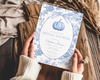 May include: A rectangular bridal shower invitation card featuring a blue and white floral toile pattern, a central oval frame, a light blue bow, and a blue pumpkin illustration. The text reads: PLEASE JOIN US FOR A BRIDAL SHOWER IN HONOR OF Sophia James.