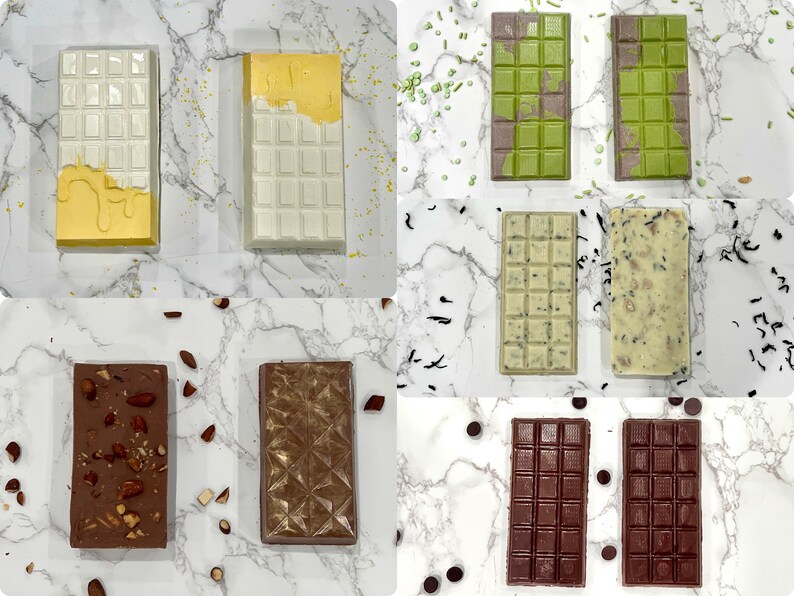 May include: Assortment of chocolate bars with different toppings and flavors.  The bars are arranged in a grid pattern on a white marble surface.  The toppings include almonds, sprinkles, and tea leaves.