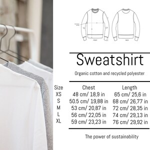 May include: White, gray, and white sweatshirts hanging on a rack. The image includes a diagram of a sweatshirt and text that reads "Sweatshirt, Organic cotton and recycled polyester." Size chart with chest and length measurements in inches and centimeters.