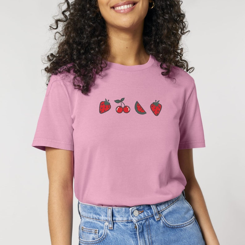 May include: A pink t-shirt with a graphic of strawberries, cherries, and watermelon slices.