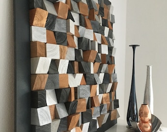 May include: A geometric wall art piece made of wood blocks in shades of gray, brown, and white. The blocks are arranged in a random pattern to create a modern and abstract design.