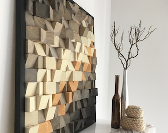 May include: A large, geometric wooden wall art piece with a black frame. The artwork features a gradient of colors, transitioning from light beige to dark gray. The design is made of various wooden blocks.