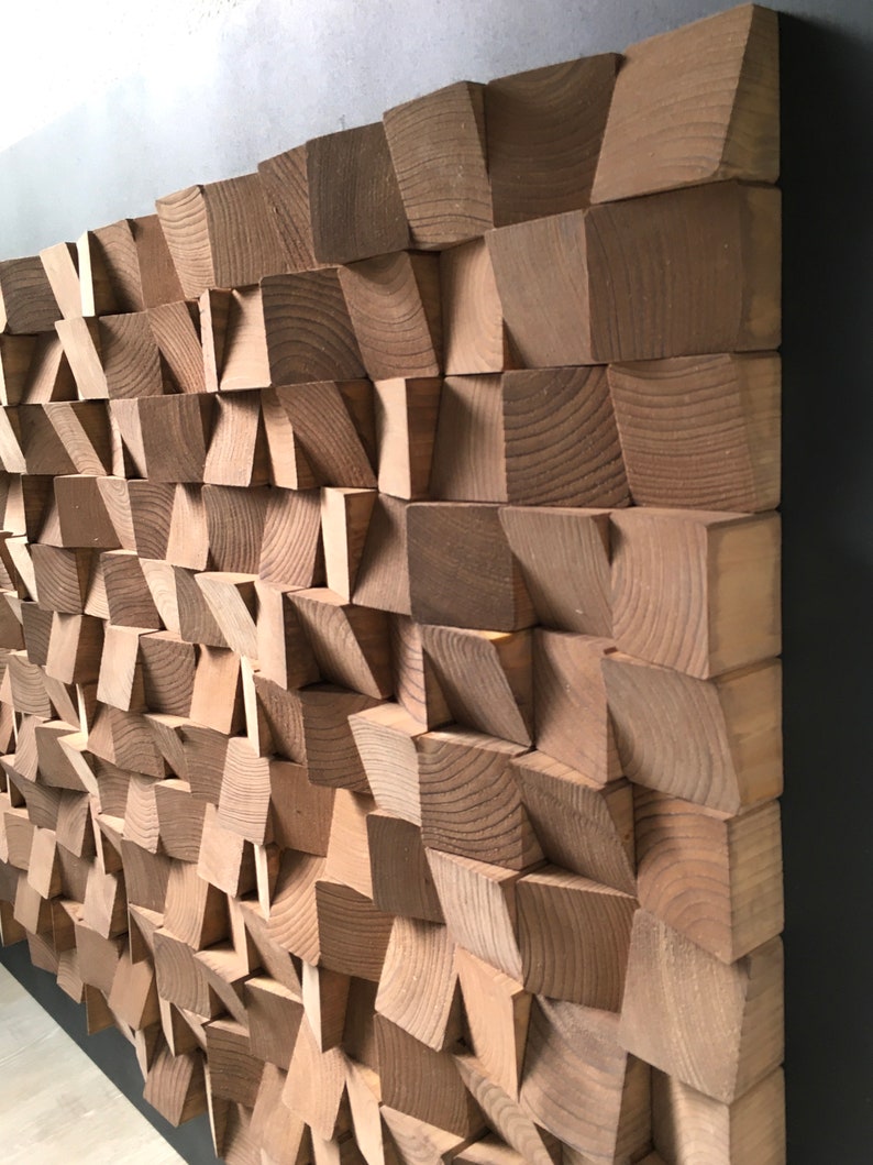 Puede incluir: Una pieza de arte de pared hecha de madera con un patr&oacute;n geom&eacute;trico. La madera es de color marr&oacute;n claro y las piezas est&aacute;n dispuestas en un patr&oacute;n escalonado.