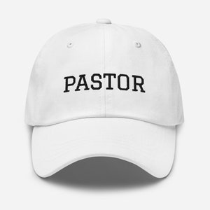 May include: White baseball cap with black text that reads "PASTOR".