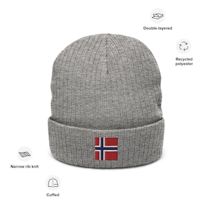 May include: Gray knitted beanie with a cuffed brim and a small embroidered Norwegian flag on the front. The beanie is made from recycled polyester and is double-layered.