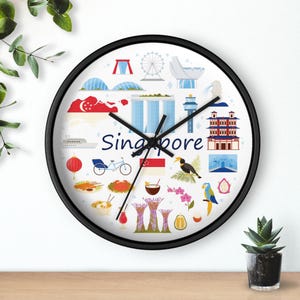May include: A round wall clock with a black frame. The clock face features a white background with illustrations of Singapore landmarks and the word "Singapore" in blue. The clock hands are black.
