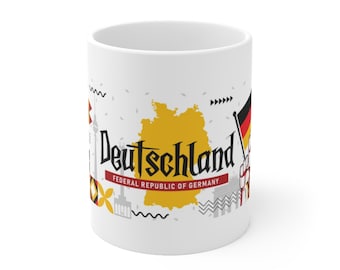 May include: White ceramic mug with a graphic design featuring a yellow outline of Germany, the word "Deutschland", and the text "Federal Republic of Germany".