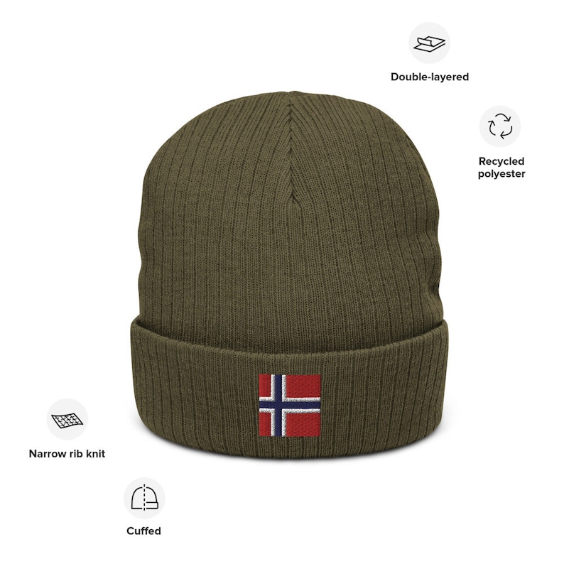 May include: A green knitted beanie with a cuffed brim and a small embroidered Norwegian flag on the front. The beanie is made from recycled polyester and is double-layered.