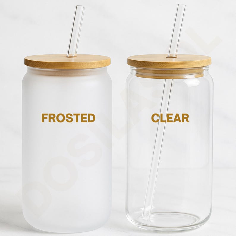 May include: Two glass drinking jars with bamboo lids and clear glass straws. One jar is frosted and labeled "FROSTED" in gold lettering, the other is clear and labeled "CLEAR". The jars are on a white surface.