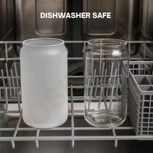 May include: Two glass can-shaped tumblers, one frosted and one clear, sit in a dishwasher rack. The frosted glass has a soft, opaque appearance. The clear glass shows the interior rack. The text "DISHWASHER SAFE" is above the glasses.