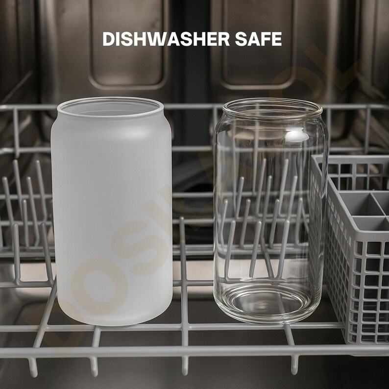 May include: Two glass can-shaped tumblers, one frosted and one clear, sit in a dishwasher rack. The frosted glass has a soft, opaque appearance. The clear glass shows the interior rack. The text "DISHWASHER SAFE" is above the glasses.