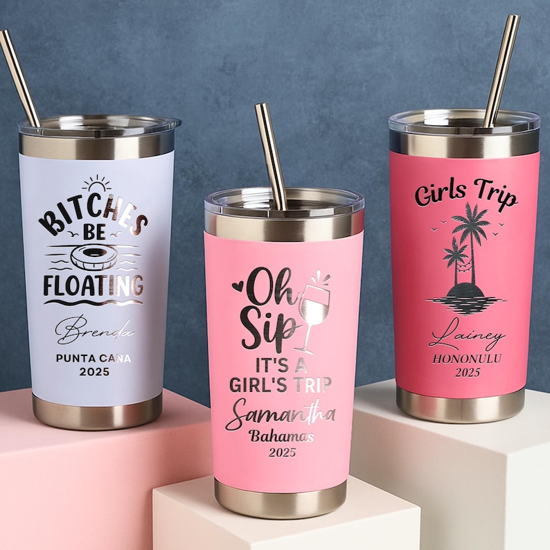 May include: Three stainless steel travel tumblers with gold straws. One is white with "BITCHES BE FLOATING" text, another is pink with "Oh Sip IT'S A GIRL'S TRIP" text, and the last is pink with "Girls Trip" text.