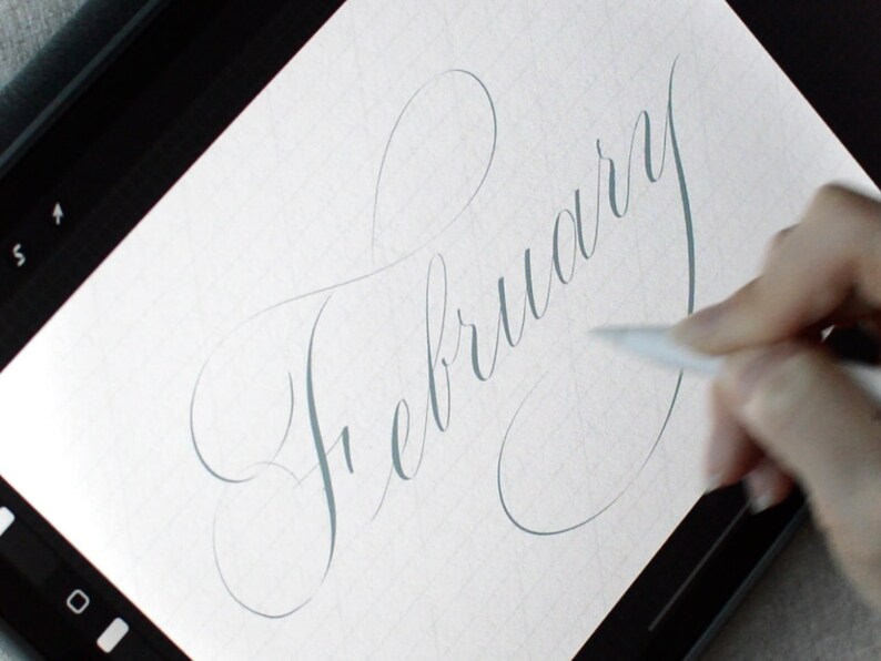 May include: A close-up of a hand writing the word "February" in cursive on a digital tablet.