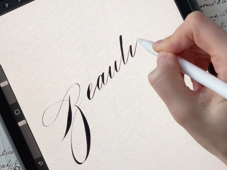 May include: A close-up of a hand writing the word "Beauty" in cursive on a digital tablet using a white stylus.
