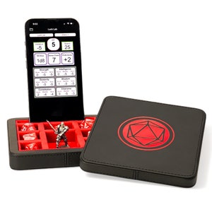 May include: A black leather dice tray with a red D20 symbol on the lid. The tray has compartments for dice and a small figure. A black smartphone with a red and white app interface is in the background.
