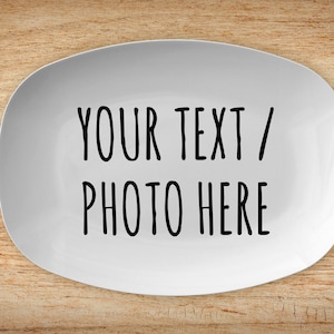 May include: White oval ceramic plate with the text "YOUR TEXT / PHOTO HERE" printed in black.