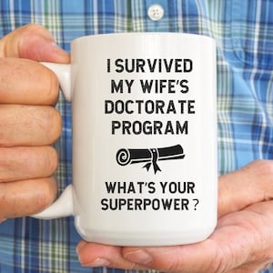Kubek z napisem „Przeżyłem program doktorancki mojej żony”, prezent dla doktoranta, kubek na kawę dla doktoranta, prezent z okazji ukończenia studiów doktoranckich, prezent z okazji doktoratu, mąż z doktoratem