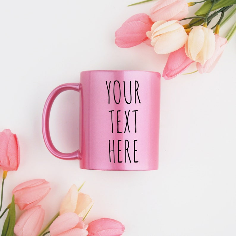 Puede incluir: Una taza de cer&aacute;mica rosa con un asa blanca. La taza tiene el texto "YOUR TEXT HERE" impreso en la parte delantera.