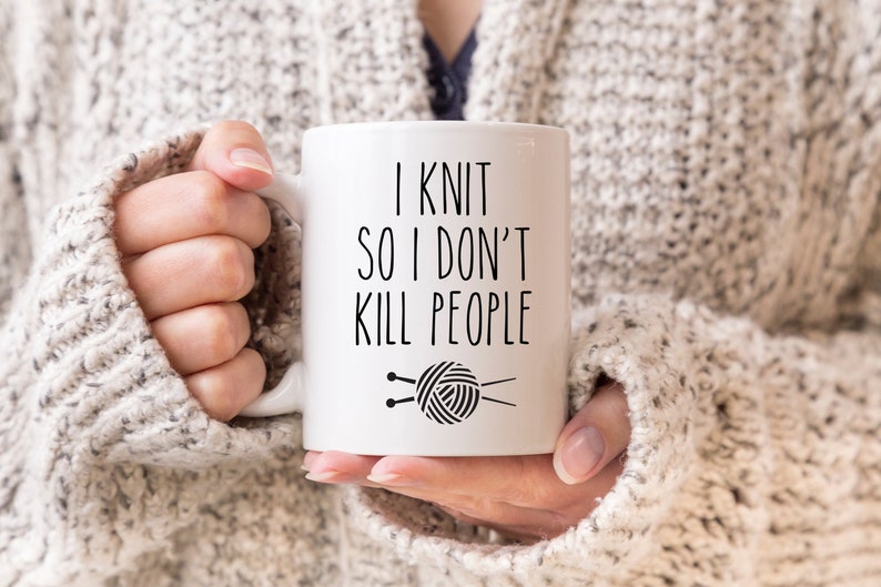 K&ouml;nnte beinhalten: Wei&szlig;e Keramiktasse mit schwarzem Text, der "Ich stricke, damit ich keine Leute umbringe" lautet. Unter dem Text befindet sich eine Schwarzwei&szlig;illustration von Stricknadeln und Garn.
