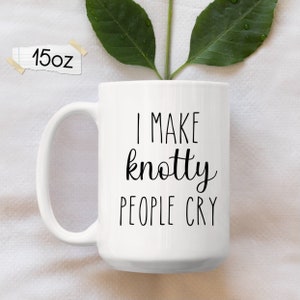 May include: White ceramic coffee mug with black text that reads "I make knotty people cry".