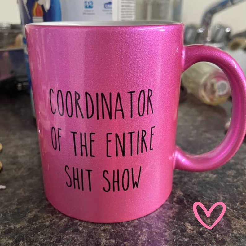 Puede incluir: Taza de caf&eacute; de cer&aacute;mica rosa con texto negro que dice "Coordinator of the Entire Shit Show".