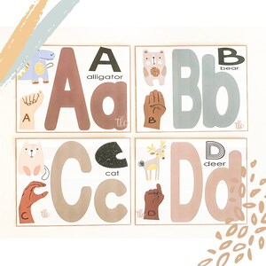 May include: Four framed educational prints featuring the letters A, B, C, and D. Each print displays a large letter, a corresponding animal illustration, the animal's name, and a hand gesture representing the letter in sign language. The color palette includes muted tones.