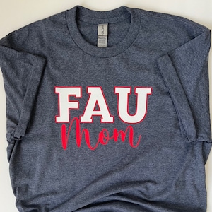 May include: A navy blue t-shirt with the text "FAU mom" in white and red lettering.
