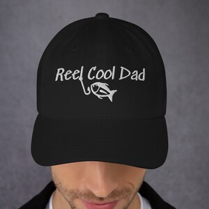 May include: Black baseball cap with white embroidery that reads "Reel Cool Dad" and a small fish graphic.