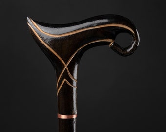 Könnte beinhalten: Ein schwarzer Gehstock aus Holz mit einem gebogenen Griff und goldenen Akzenten. Der Griff hat ein dekoratives Design.