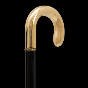 Puede incluir: Un mango de bastón de color dorado con un eje negro.